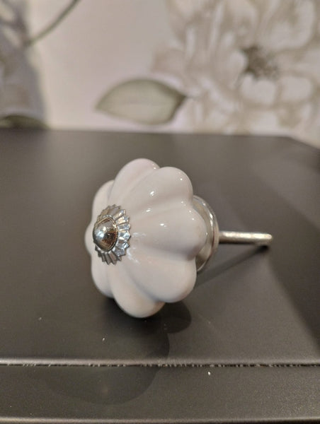 Mått: ca. Ø 4,5cm  Färg: vit  Material: Porslin/Metall  Muttrar och brickor ingår. Skruven kan enkelt kapas till önskad längd med t ex en liten bågfil. Dörrknopp