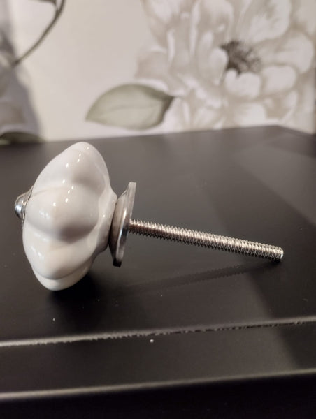 Mått: ca. Ø 4,5cm  Färg: vit  Material: Porslin/Metall  Muttrar och brickor ingår. Skruven kan enkelt kapas till önskad längd med t ex en liten bågfil. Dörrknopp