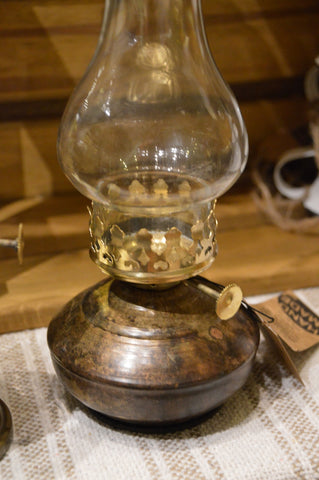 Lampa för värmeljus: Värmeljuslykta med utseendet av en gammal fotogenlampa med fot i antikmässing och glaskupa som skyddar lågan.  Mått: H 27cm   B 10cm  Till Värmeljus. Ingår ej.  Material: Emalj, Metall & Glas