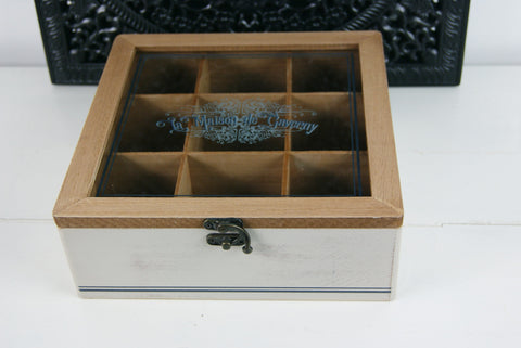 Telåda med 9 fack  Glaslock med tryck "La Maison de Gaverny"  Mått: 23x23 cm,  H 8cm  Varje fack har 7x7cm